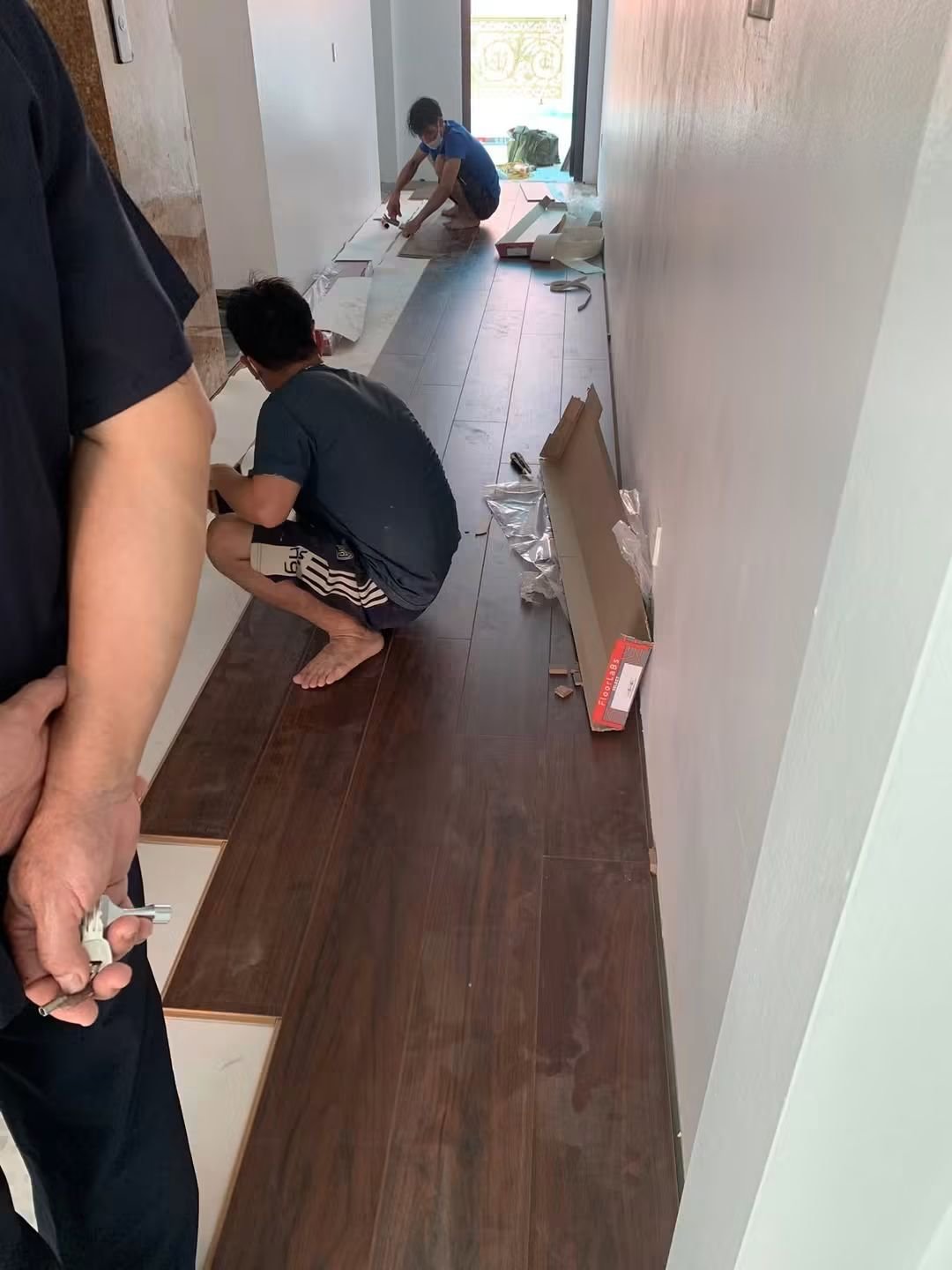 Thợ căn chỉnh mép sàn gỗ sát tường