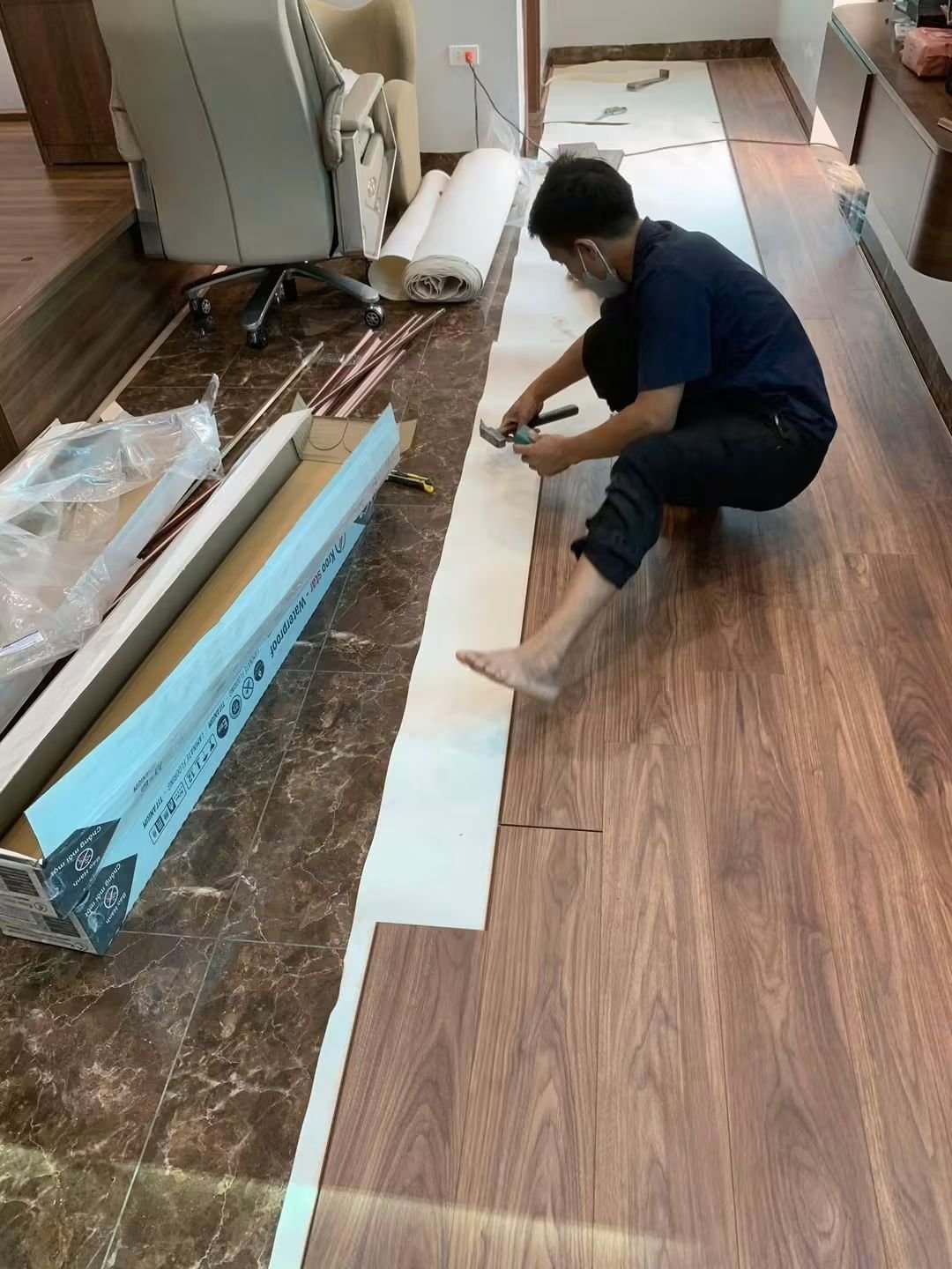 Thợ ghép tấm sàn gỗ trong phòng