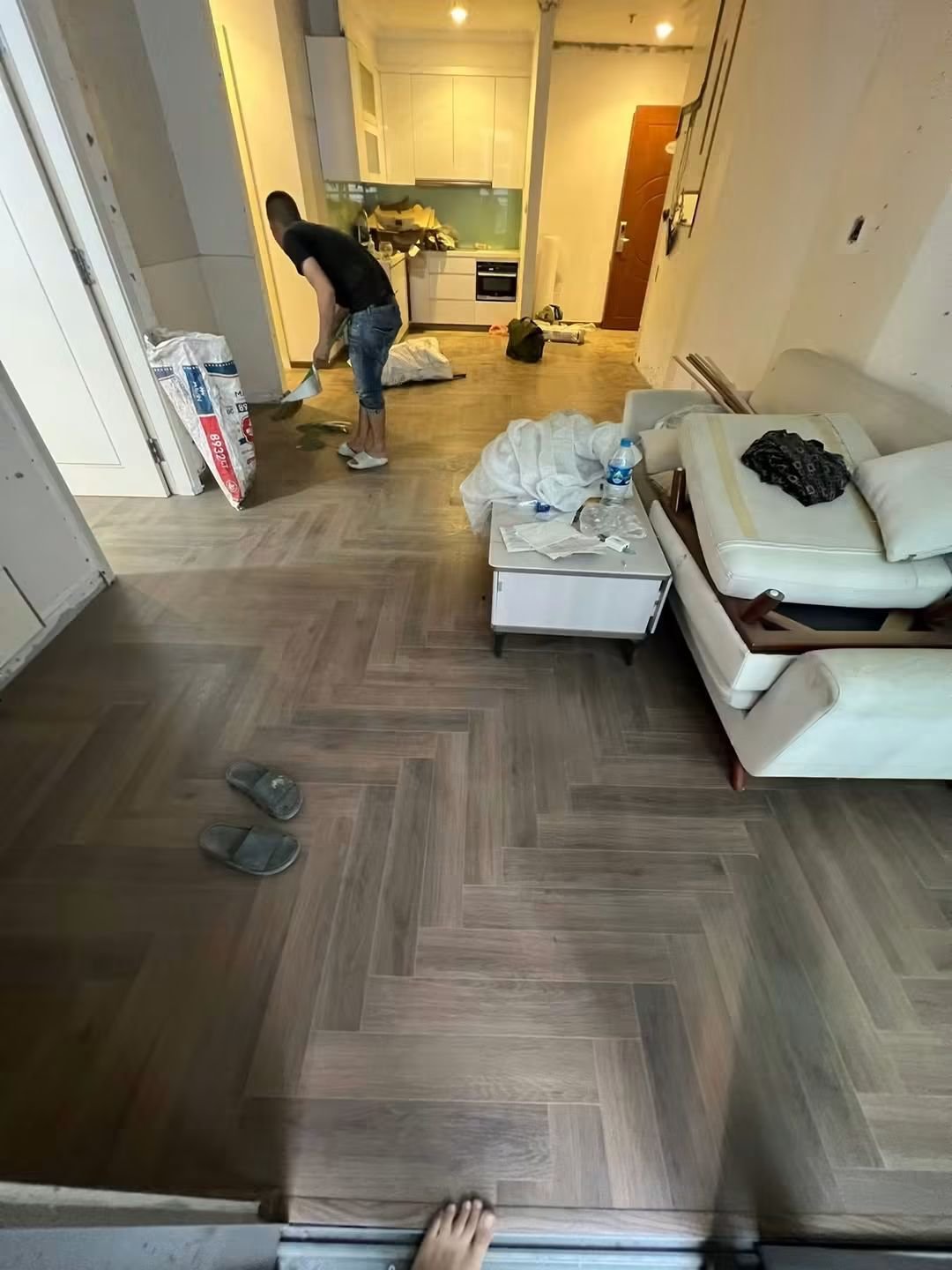 Thợ định vị tấm sàn gỗ trong phòng khách