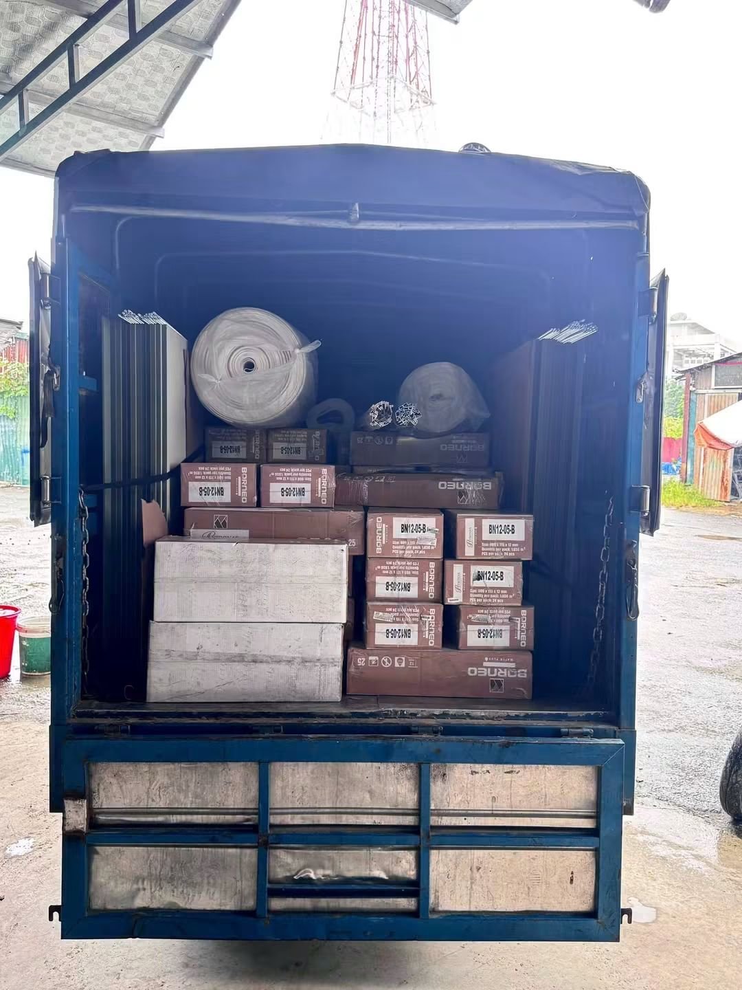 Thùng xe tải xanh chở hộp sàn gỗ
